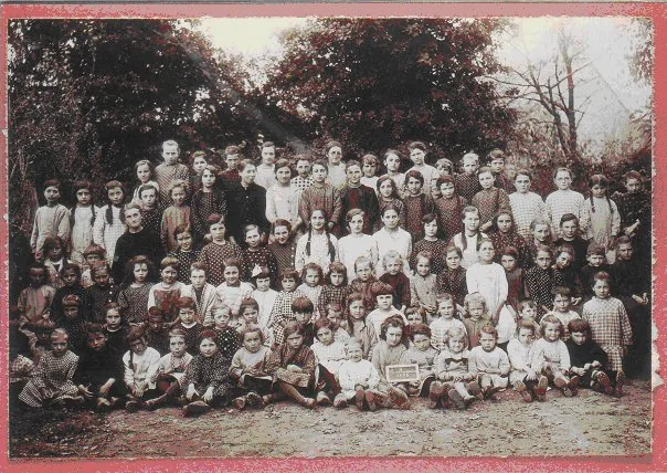 Photographie ancienne : un grand groupe de filles et leurs enseignantes, dans la cour